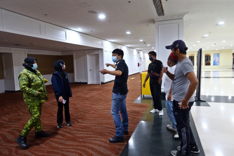吉隆坡世贸中心的负责人跟各单位工作人员讲解注射疫苗的程序及走道。
