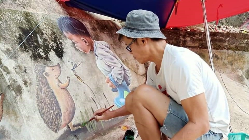 “草帽画家”赖昭光在今年初协助兄长赖兆民，为小公园的挡土墙绘制壁画。