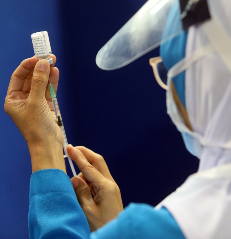 医护人员小心翼翼的抽取阿斯利康冠病疫苗。（本报摄影：蔡伟传）