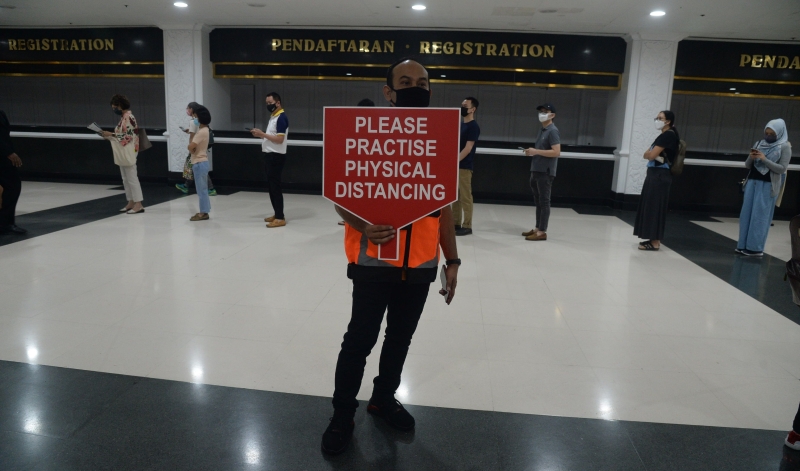 在吉隆坡世贸中心现场，处处可见工作人员拿著告示牌提醒民众遵守SOP。 （本报摄影：林明辉）