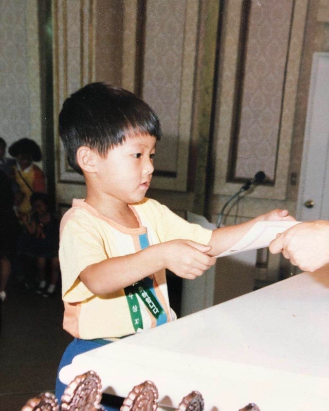 宋仲基配合韩国儿童节分享一张儿童时期的照片，乖乖接受奖状的样子让粉丝大呼“可爱”，并赞他从小就外貌出众。