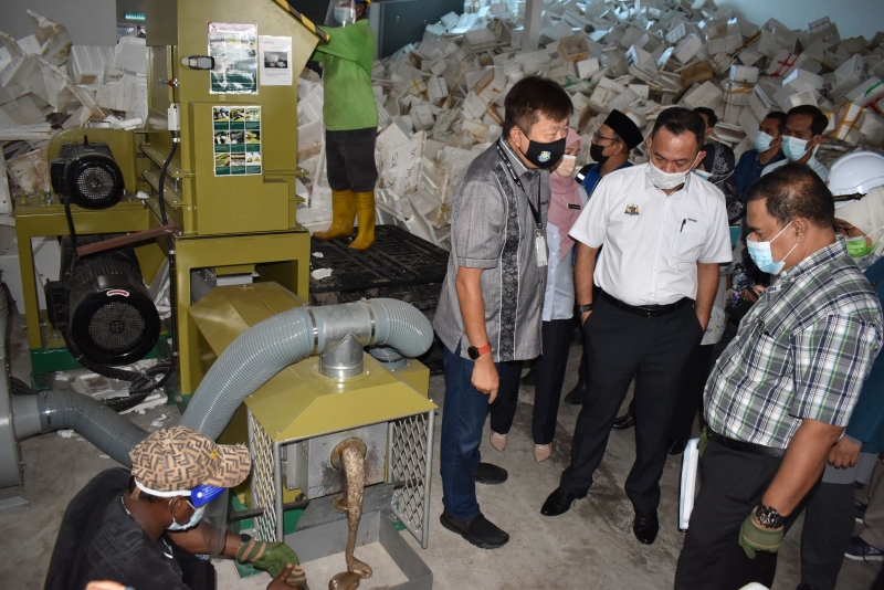 甲环境局长罗斯里（右）了解使用回收宝丽龙箱进行溶化分解的过程，右二起沙丹及宋曜强。