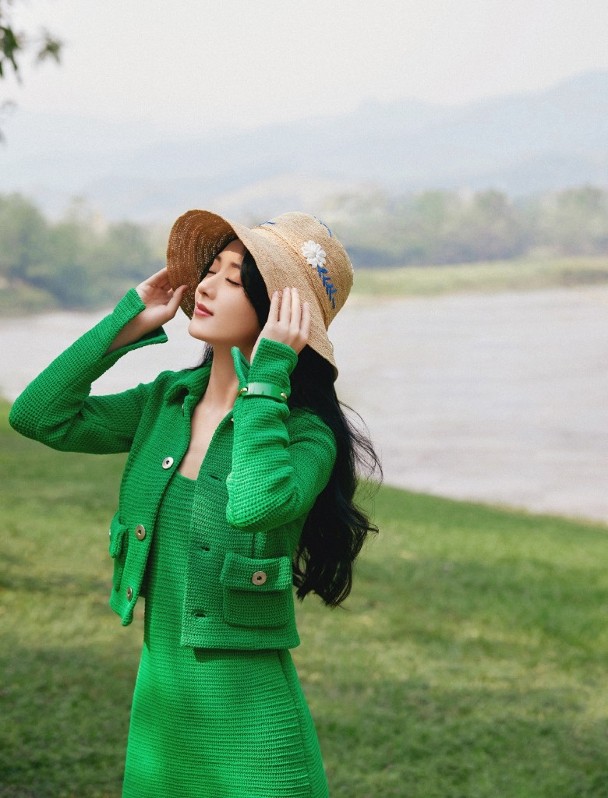 赵丽颖穿着一套绿色套装，留着波浪长发，头戴编织帽。