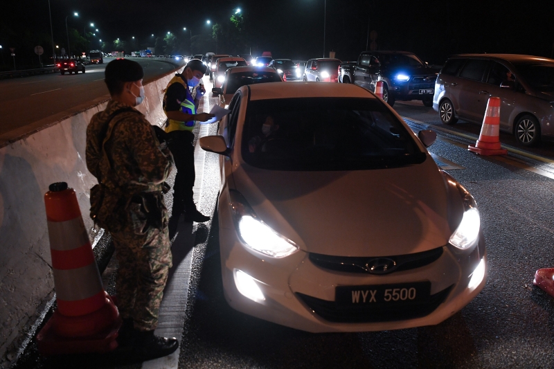 警方和武装部队在县市多处交界处设下路障，检查过往车辆。（图：马新社）