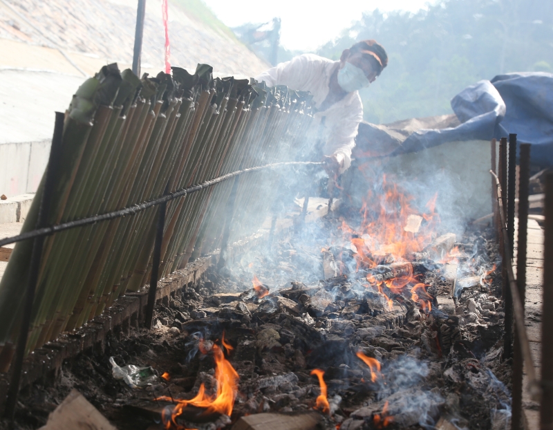 在热气腾腾的环境下制作竹筒饭一点都不好受。

