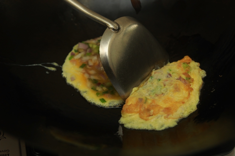 热锅加油1大匙，倒入1勺蛋混合物在锅中，煎至半凝固状态时，对折成半月形，转小火煎至两边金黄色即可。重复上述做法至煎完。