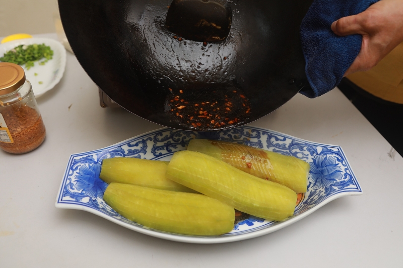 将煮好的调味料淋在节瓜上，撒下蒜油、炸蒜、芫荽碎及葱粒。