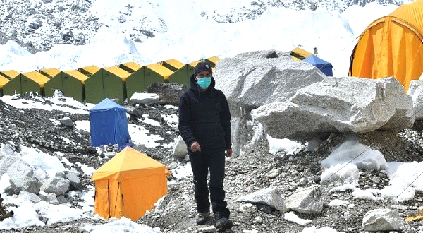 An expedition base camp staff wearing a face mask walks around Everest base camp. AFP
