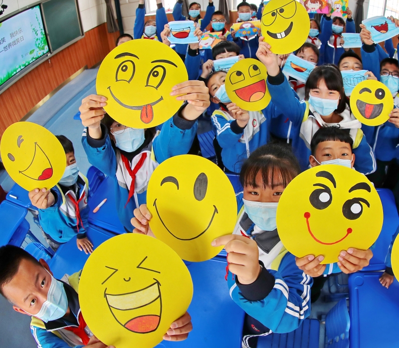 学生在"彩绘笑脸 放飞心情"展示绘制不同的笑脸。　

