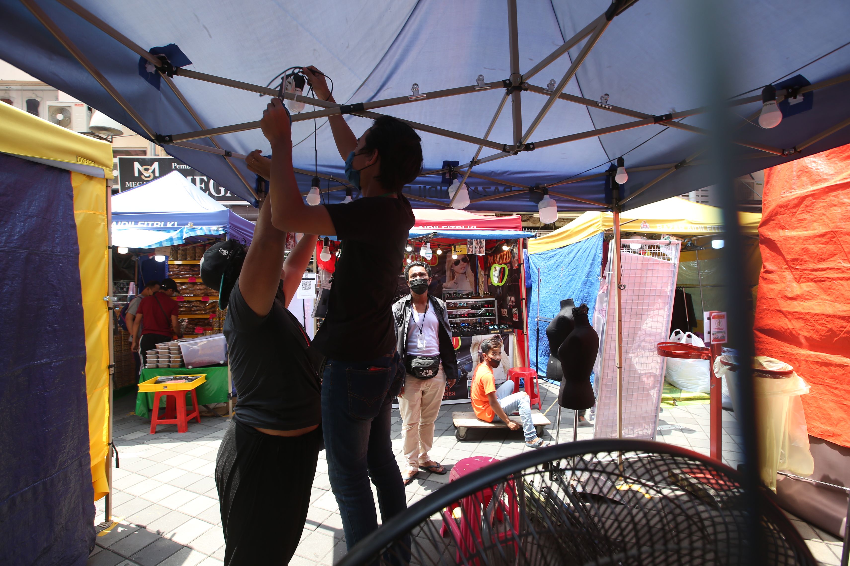 星期日是开斋节市集允许营业的最后一天，部分小贩在中午时分已开始收档。