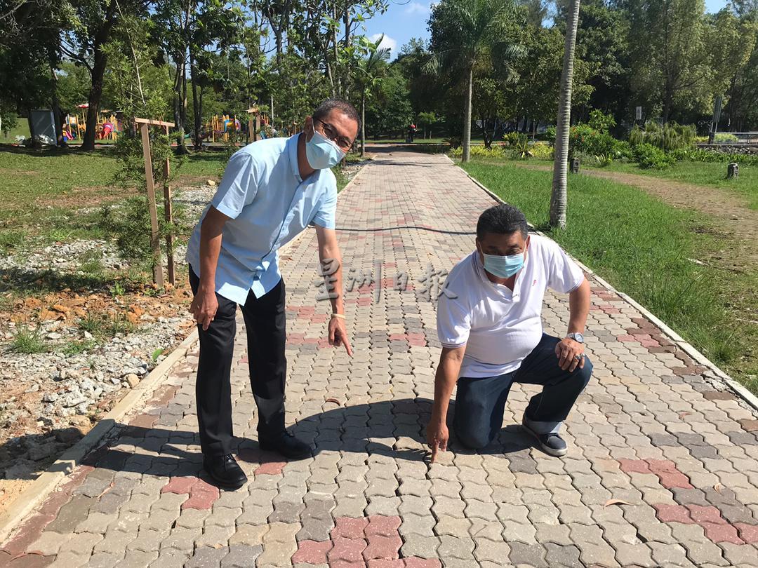 何桂文（左一起）及雷宝翔查看步道的情况，发现新建好的走道已凹凸不平，如同“波浪”走道。