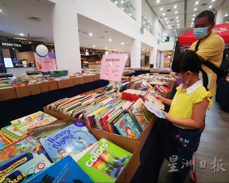 陈健铭携带孩子来选购二手童书。