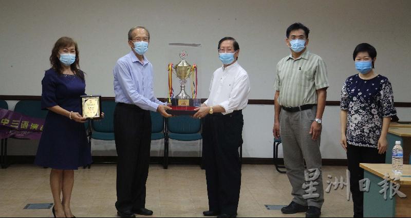 张泰卿（左二）移交全砂独中三届制挑战杯予古晋中华第一中学，由刘利民（右三）代表接领。