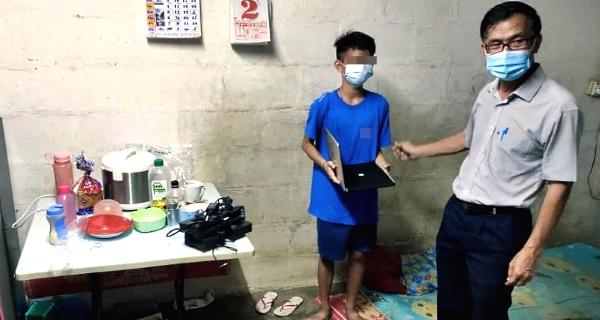 Kuala Terengganu DAP secretary Cheong Siow Foon hands over the laptop to the student at his home. Kuala Terengganu DAP secretary Cheong Siow Foon hands over the laptop to the student at his home.