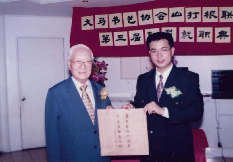 笔者（薛君毅）颁发纪念品予拿督佘智瑞（左）。