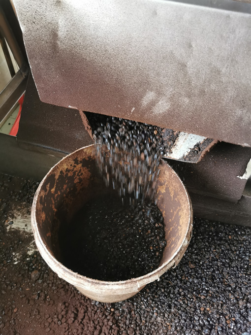 将炒好的咖啡豆放入机器中打散。