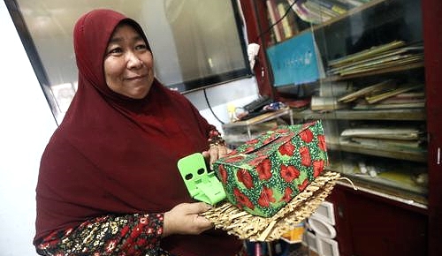 Lina shows the tissue box cover sewn by her during the training sessions. Lina shows the tissue box cover sewn by her during the training sessions.