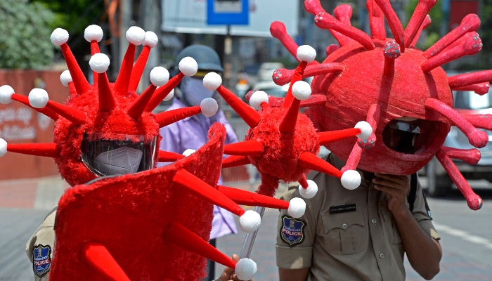 Police in COVID-19 headgear urge people to adopt safety protocols during an awareness campaign in Hyderabad, India. AFP