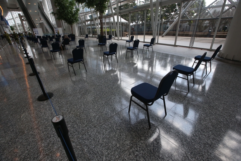 MITEC大厅摆放椅子，让民众保持距离地坐着等候。
