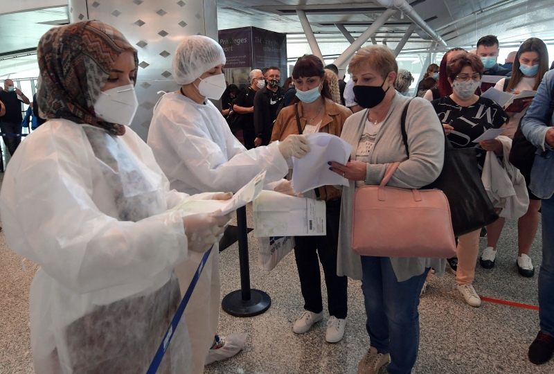 突尼西亚医护人员在位于地中海度假城市苏塞国际机场检查欧洲旅客的冠病证件，做好防疫把关工作。（图：法新社）