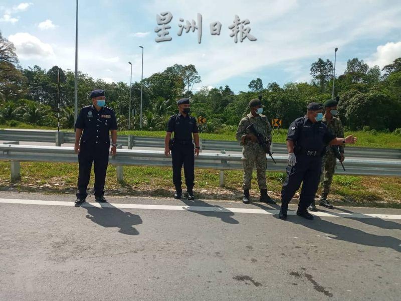 诗巫警区主任史丹里（左）昨早前往芦仙的路障巡视，指示该处军警严加检查往来车辆，以免监狱逃犯逃出诗巫。