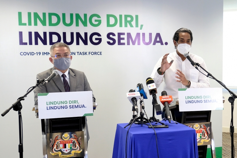凯里（右）和阿汉峇峇（左）在联合新闻发布会上汇报国家冠病疫苗接种计划及冠病疫情的最新进展。