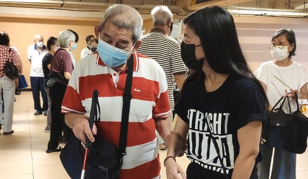 Lim Yi Wei (R) is helping a partially blind senior citizen at the vaccination center at Sunway Convention Center. Lim Yi Wei (R) is helping a partially blind senior citizen at the vaccination center at Sunway Convention Center.