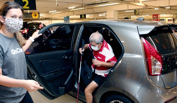 A GoCar volunteer is sending a senior citizen to a vaccination center. A GoCar volunteer is sending a senior citizen to a vaccination center.