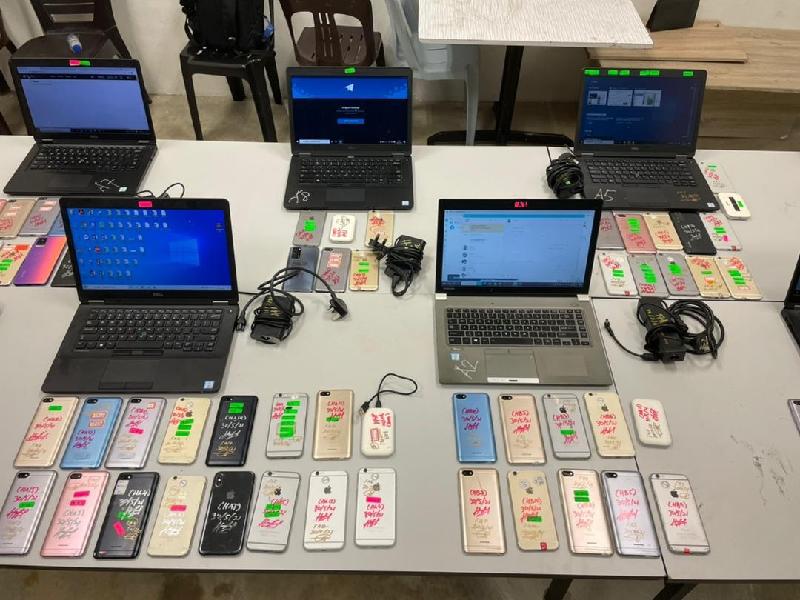 警方起获的部份手提电脑和手机。