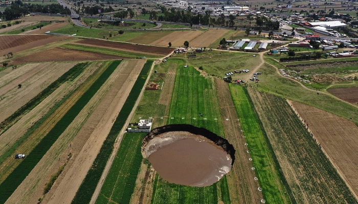 Aerial view of a sinkhole that was found by farmers in a field of crops in Santa Maria Zacatepec, Mexico on June 1, 2021. AFP