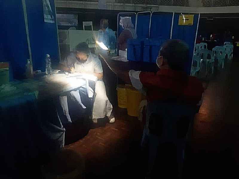 位于兵南邦文化中心的冠病疫苗接种中心周六下午停电，民众使用手机电筒帮忙照明补光。