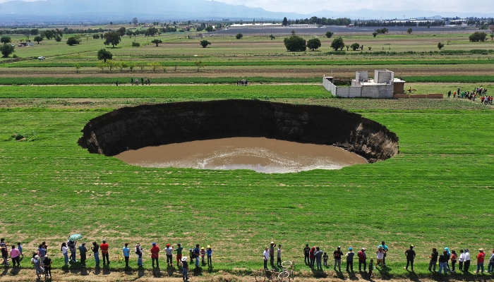 Aerial view of a sinkhole that was found by farmers in a field of crops in Santa Maria Zacatepec, Mexico on June 1, 2021. AFP Aerial view of a sinkhole that was found by farmers in a field of crops in Santa Maria Zacatepec, Mexico on June 1, 2021. AFP