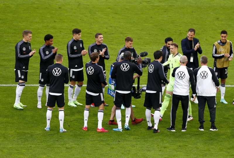 诺伊尔（绿衣者）此役迎来德国生涯百场里程碑，为队史门将第1人。图为赛前诺伊尔入场时获队友列队迎接。（欧新社照片）