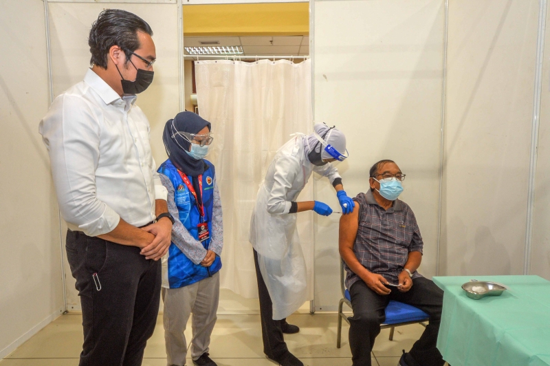 旺阿末法依沙（左）巡视疫苗接种中心，以了解MyVac志愿者的服务情况。


