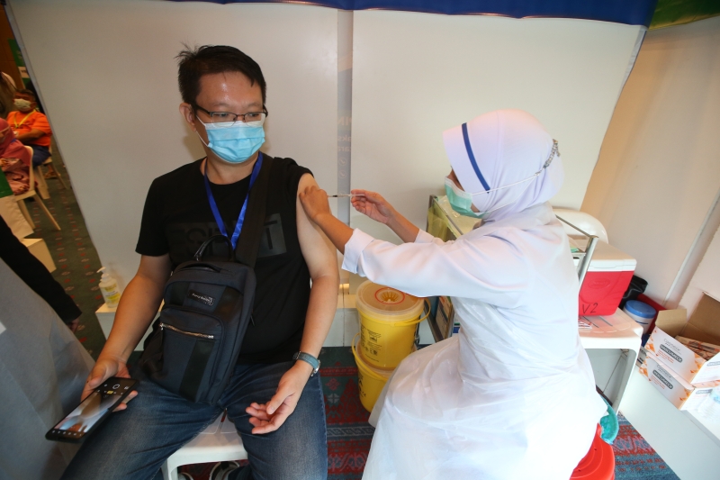 本报摄影记者陈世伟非常淡定的接受护士注射疫苗。 （本报摄影：黄安健）

