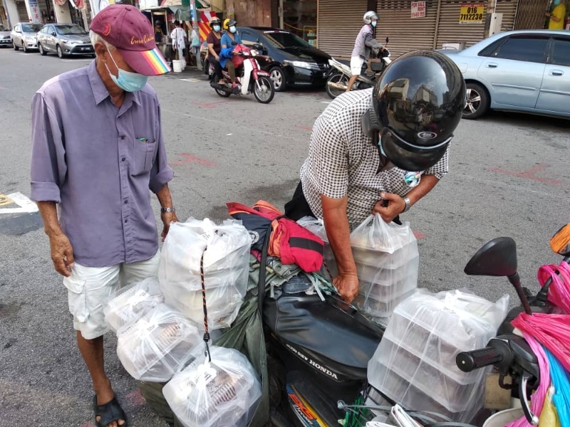 其中一名义工以摩托车载送饭盒予有需要的人士。