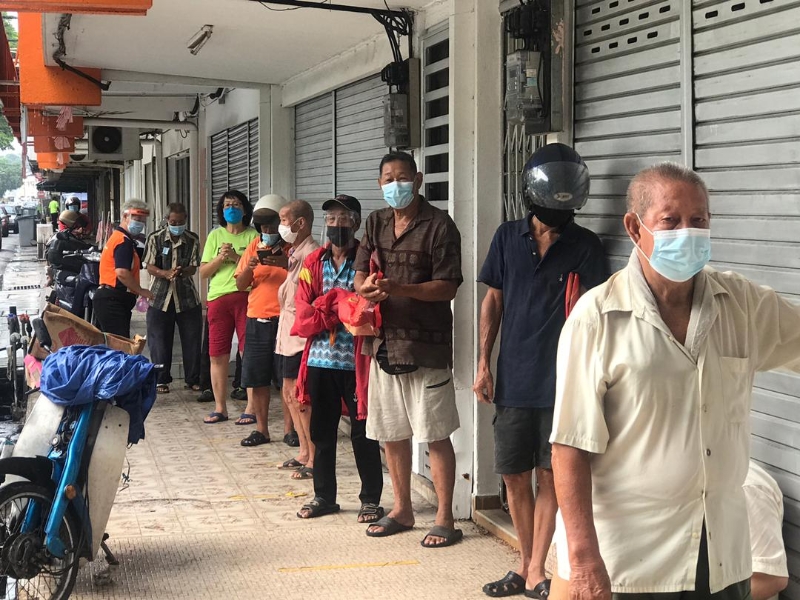 受惠者皆遵守SOP,在领取饭盒前先洗手及测量体温。