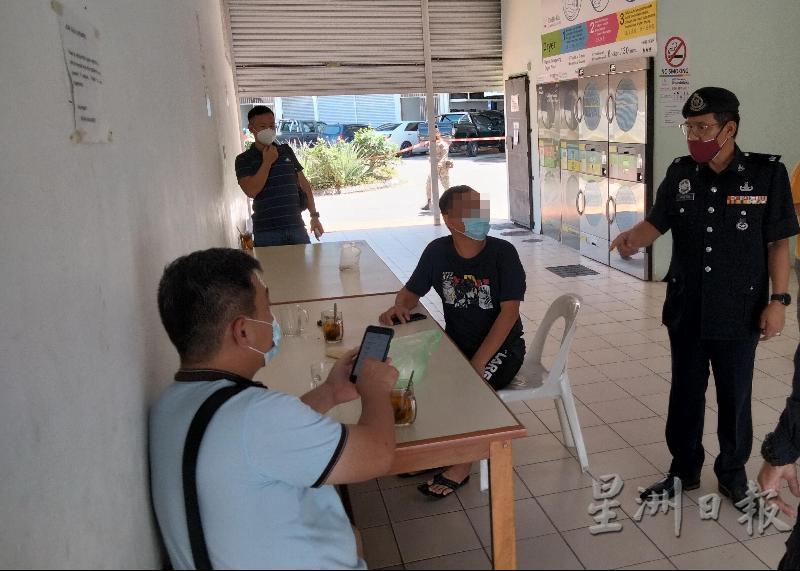 3名男子在自助洗衣店内吃喝，被诗巫警方防范罪案和社区安全警察组主任阿里菲（右）发现，当场指示他们离开洗衣店。