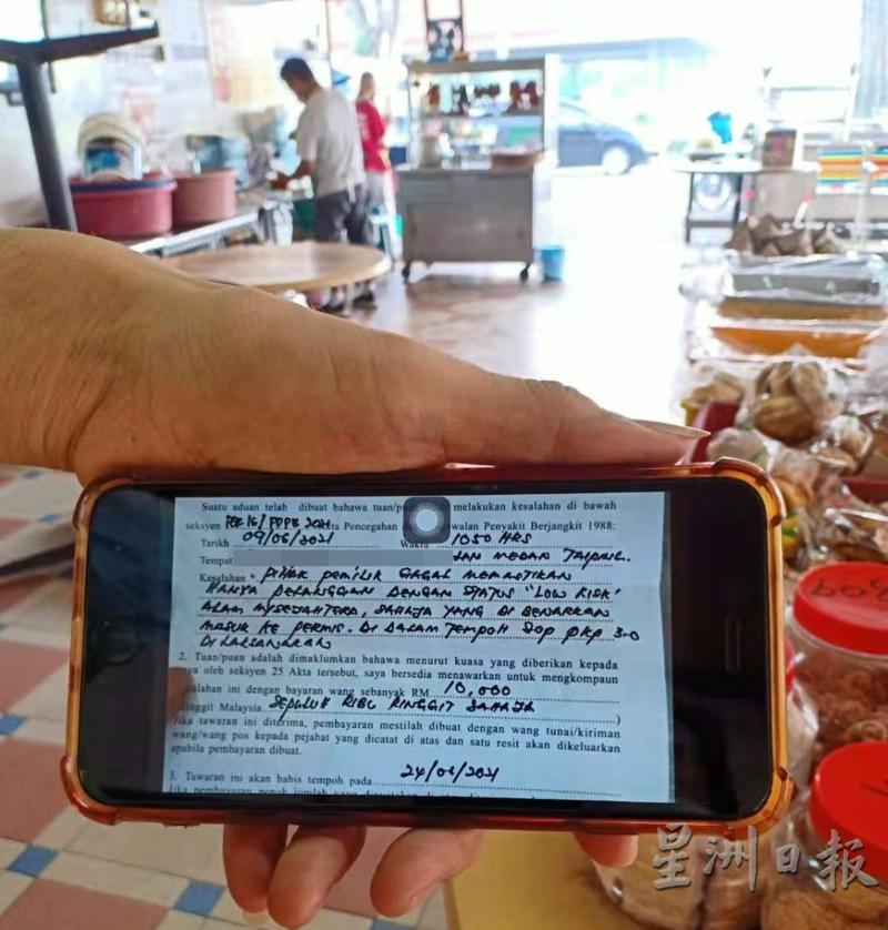 黄湫权通过手机，展示接获的1万令吉罚单。