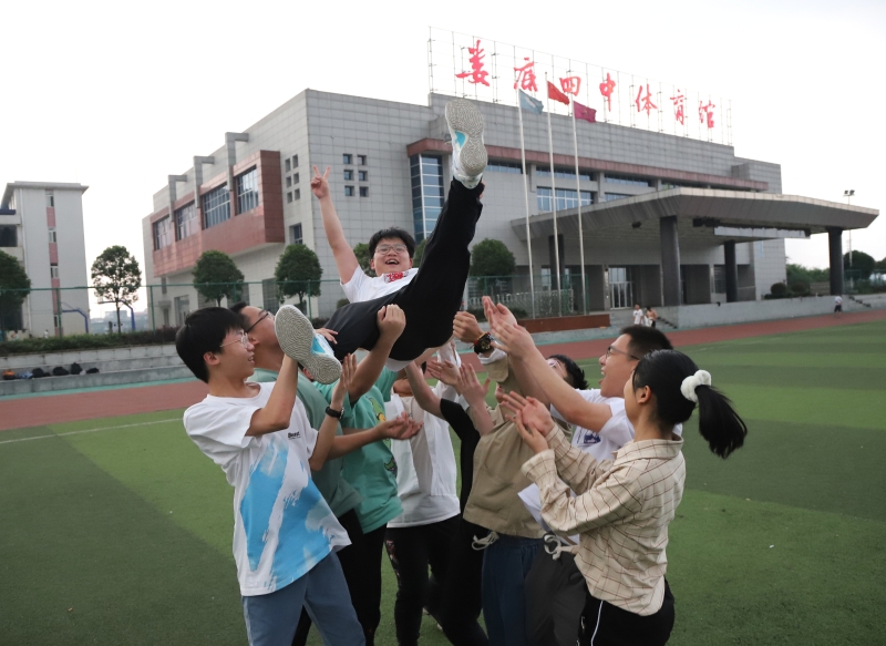 离开考场的老三李庆民被同学们抛向空中，庆祝顺利完成高考。