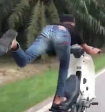 1名巫裔男子涉嫌危险驾驶，在行驶途中拉起摩托车前轮，单脚站在坐包上，一脚悬空而被警方逮捕。