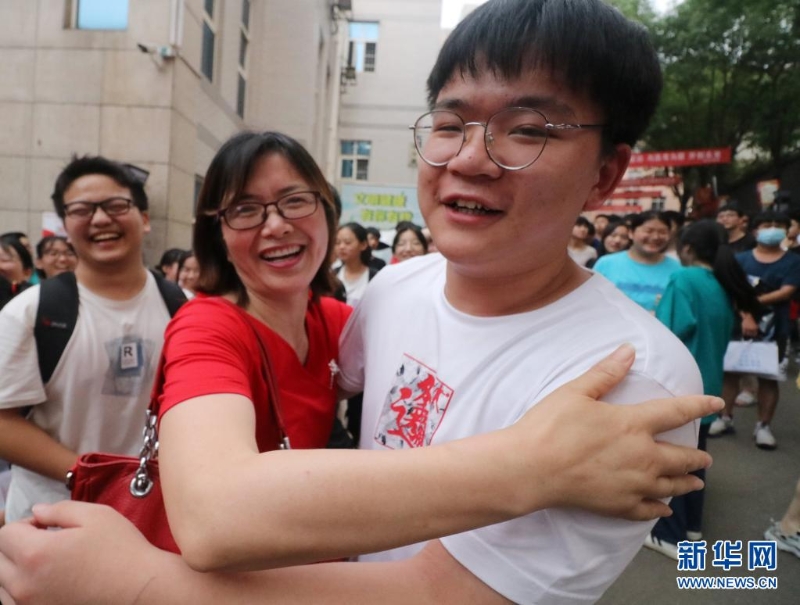 在湖南省娄底市第二中学考点，走出考场的老三李庆民和班主任舒老师拥抱。