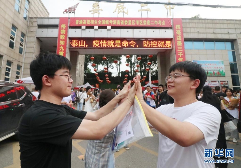 老大李庆国（左）和老三李庆民考完最后一科生物后，在校门口相遇。