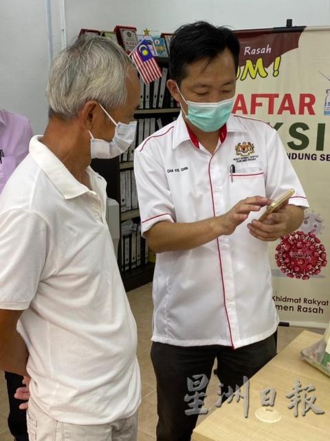 谢琪清（右）为市民登记接种冠病疫苗。