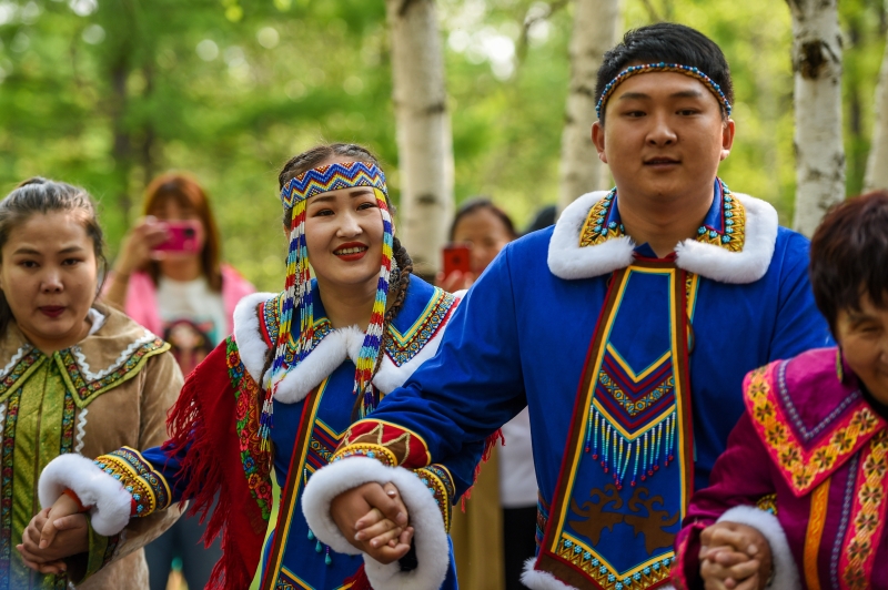 新郎侯磊（右二）和新娘何琦韩（前左二）在婚礼上与鄂温克族人载歌载舞。（图：新华社）　

