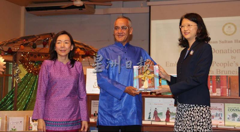 
于红（右）代表中国驻汶莱大使馆向苏丹基金局学校捐赠202册图书，由该校首席执行员莫哈末菲里迪代表领取。左为张丽珍。