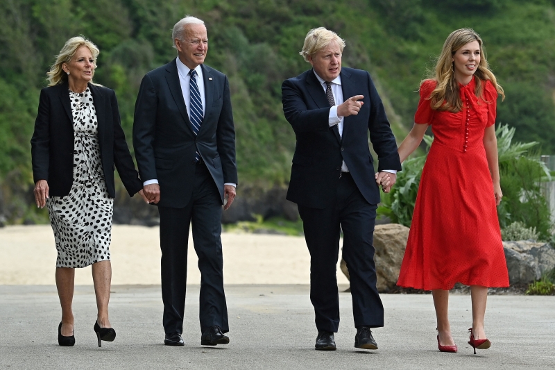 拜登(左二)与约翰逊(右二)与夫人欣赏英格兰南部圣艾夫斯湾海景。33岁的凯莉（右一）第一次以英国第一夫人的身份，出席官方场合，穿了一袭鲜红色及膝长裙，十分惊艳，与约翰逊手拖著手，十分恩爱。（法新社照片）