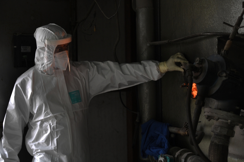 市政局火化场工作人员在处理染疫者遗体时，必须穿上全副个人防护装备（PPE）严阵以待。