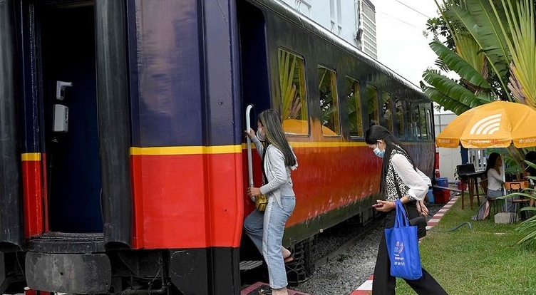 People walking into a train carriage converted into a cafe at a railway station in Phnom Penh. AFP