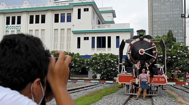 People posing for pictures in front of a train at a railway station in Phnom Penh. AFP